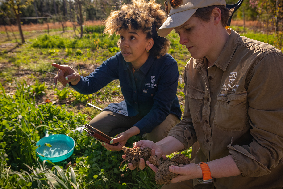 Dianna Bagnall (right) examines soil during a field visit with a colleague. The Soil Health Institute aims to make sustainable ag practices profitable for U.S. farmers. Their work wouldn’t be possible without federal funding. Photo courtesy of Dianna Bagnall.