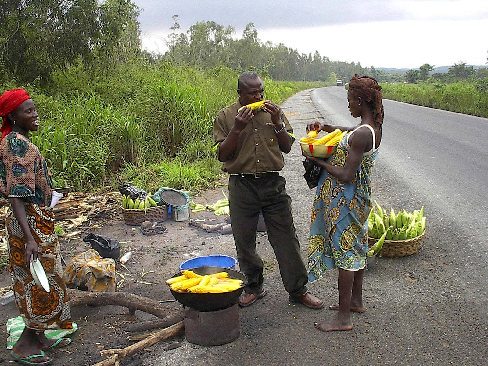 A driver enjoying boiled yellow maize sold by street vendors