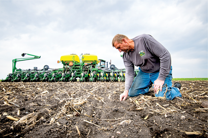 Iowa farmer Jeff Frank checks the quality of soybean planting after using the online simulator. Photo by Joseph L. Murphy/Iowa Soybean Association.