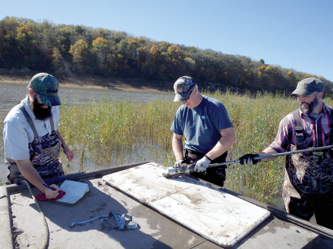 Researchers (l to r: Matthew Streeter, Keith Schilling, and Tom Stoeffler) from the Iowa Geological Survey collect a soil sample from the Lake Red Rock delta in central Iowa. Photo by Todd Goss- elink, Iowa Department of Natural Resources.