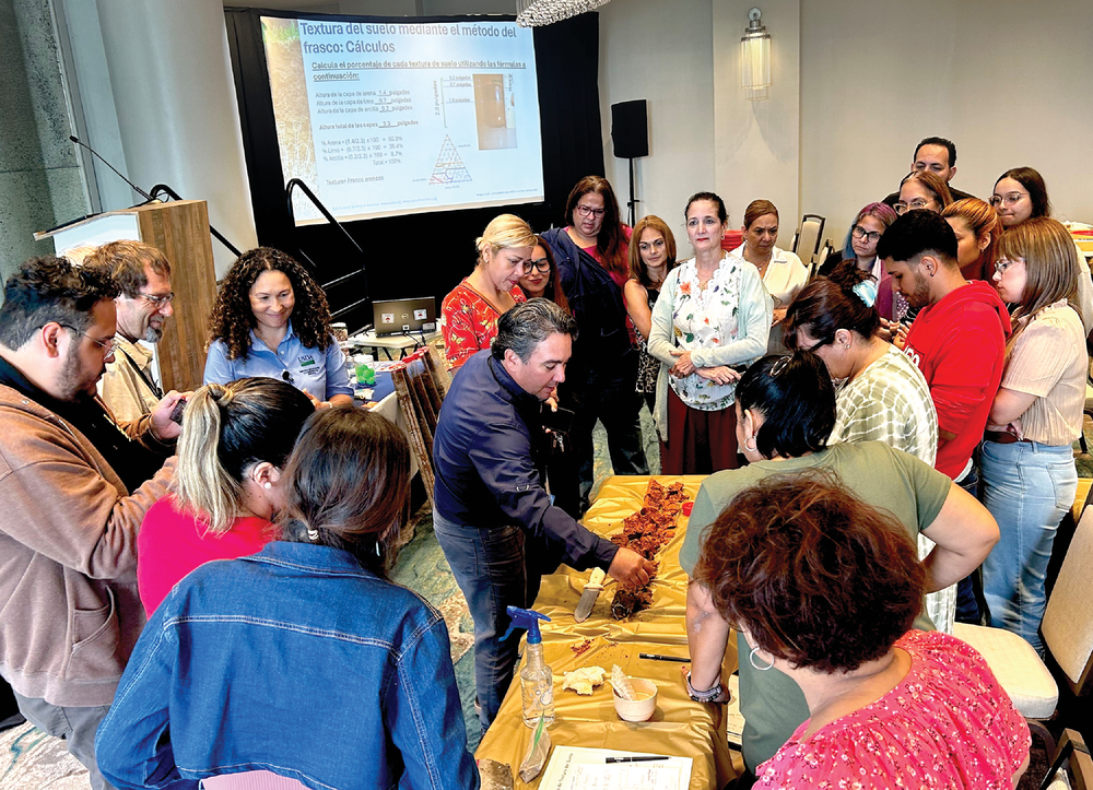 Manuel Matos muestra un perfil de suelo durante el taller y señala los diferentes horizontes que lo componen. Crédito de la foto: Samuel Rios.