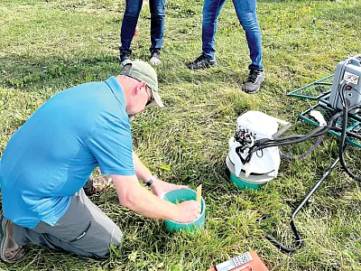 Perejiti Bekewe demonstrates a LI-COR unit to Cornell Cooperative Extension Educator Katelyn Miller and SWCD employee Brian Hall at the Cornell Field Crop Annual Field Day on the research farm in Aurora, NY.