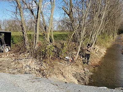 Left: Mitchell Richardson setting up the automated GHG sampling system. A component of the sampling system is an SRI gas chromatograph for gas concentration measurements integrated with a Campbell Scientific Data Logger to control sampling equipment. Right: Here Richardson is shown maintaining GHG sampling equipment at the field sampling site. On his left is a LI-COR flux gas chamber with orange flags to mark the location of the soil gas samplers along with the trailer housing the GHG sampling system.
