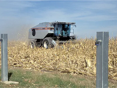 A combine passes through the field with groundwater wells in the foreground. USDA-ARS photo by Newell Kitchen.