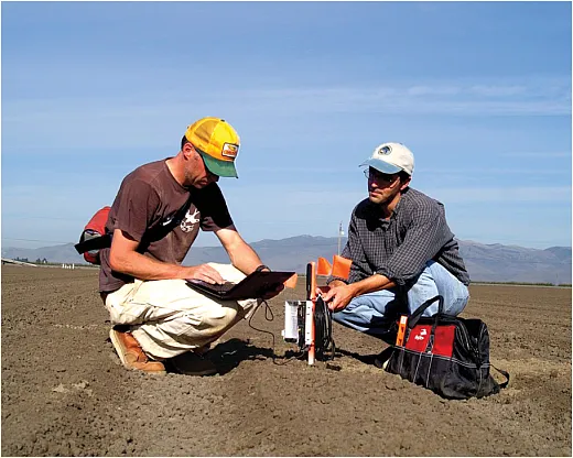 Soil moisture probes track soil salts and nutrients moving through soil profiles with water. Here, research scientists check data being returned from a wireless soil moisture monitoring network, installed in an agricultural field. Photo of courtesy of Forrest S. Melton/NASA.
