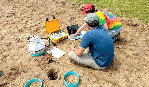 University of Tennessee Ph.D. students Kyle Brown (front) and Alexis Gillmore use an infrared gas analyzer to measure soil respiration in field sites as part of their research on degradation rates of biodegradable mulch. Photo by Morgan Isaacs.