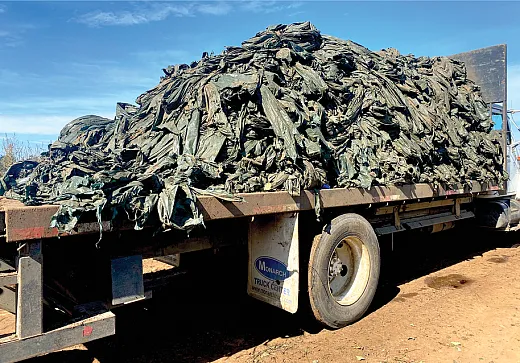 A load of plastic mulch pulled up after a season of use is trucked away to a landfill. Photo by Seeta Sistla.