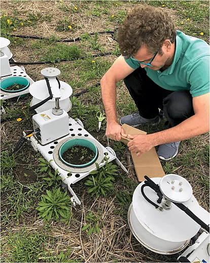 Deepak Joshi, assistant professor of remote sensing and precision agriculture at Arkansas State University, sets up LI-COR long-term chambers in the field for continuous CO2 and N2O emissions measurements. Photo courtesy of Deepak Joshi.