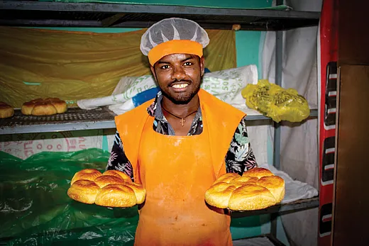 A baker at Duwame Bakery shows off the golden brown orange- fleshed sweet potato (OFSP) bread. Photo by Frezer Asfaw.